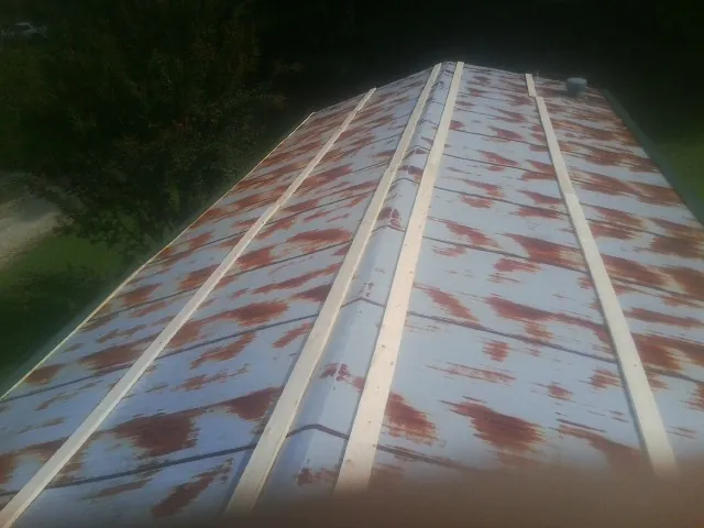 Rusted metal roof panels with new wood purlins before replacement — Storm Damage Roof Repair in Monponsett by Roofing Brothers