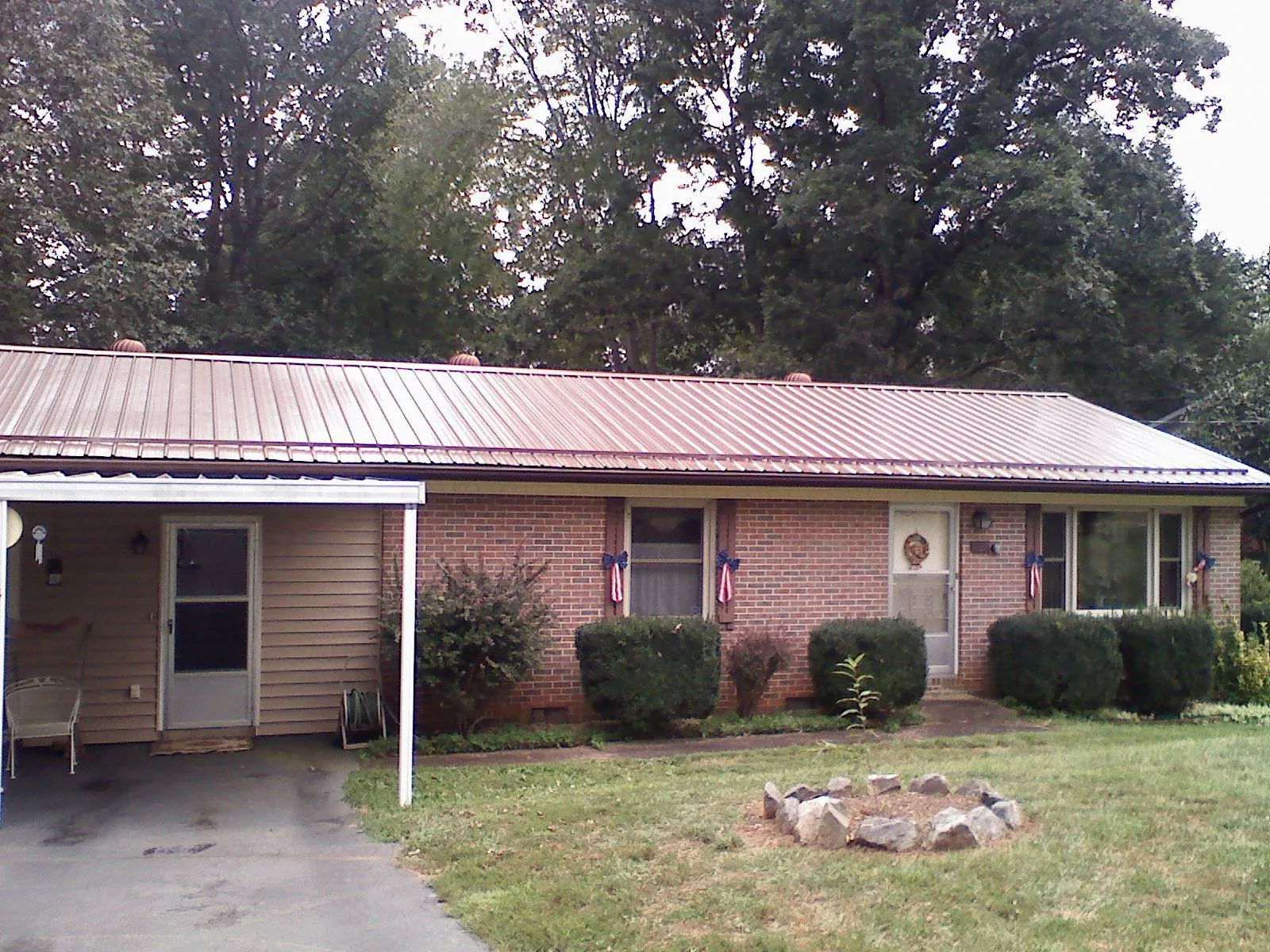 Bronze metal roof and carport on a brick ranch home — Roof Repair work by our crew in Monponsett